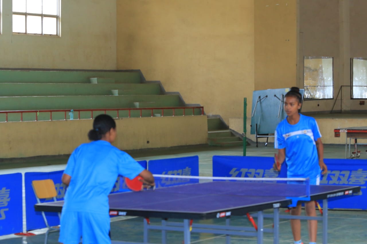 Young players practicing across a table tennis table
