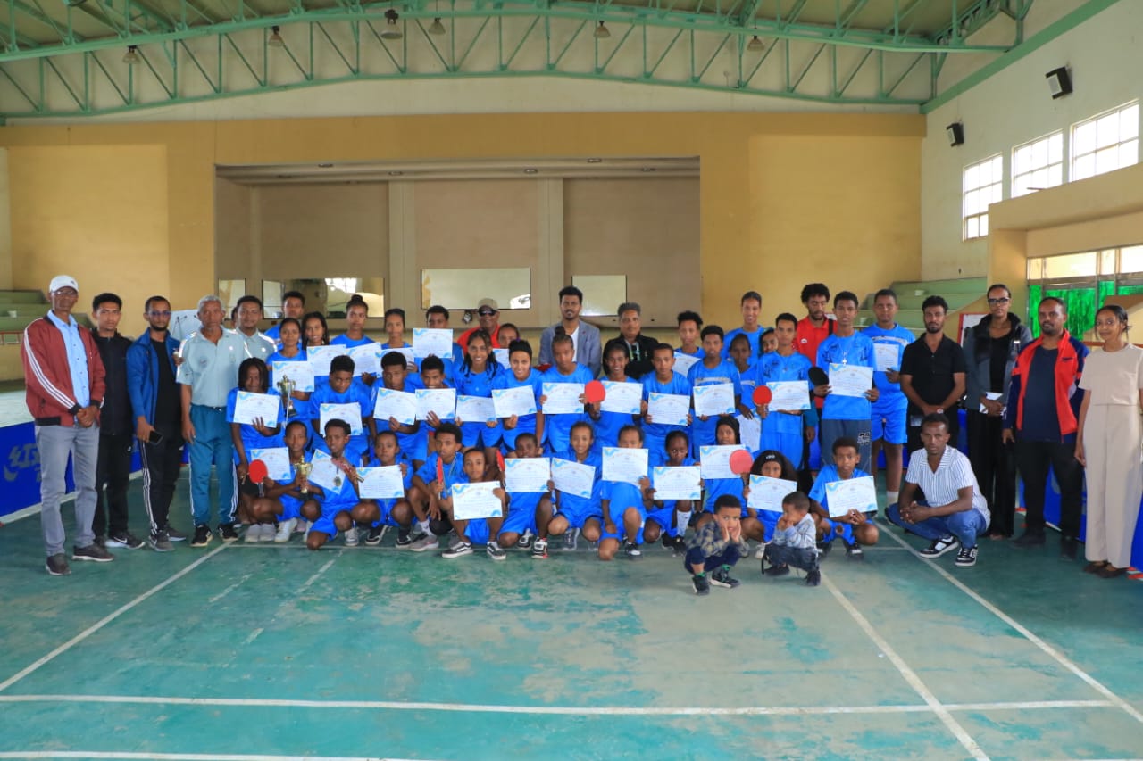 Young table tennis players and organizers posing together at the program