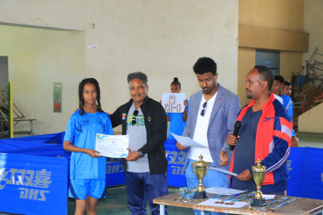 A participant receiving a certificate beside program representatives