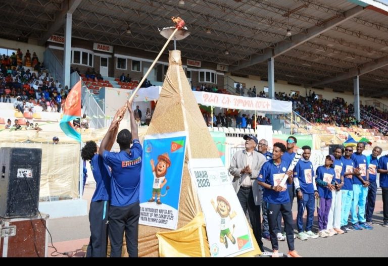 Lighting the ceremonial torch at Asmara Stadium during the Dakar 2026 Flame Tour.